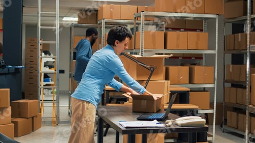 Preview: Young startup owner putting merchandise in boxes