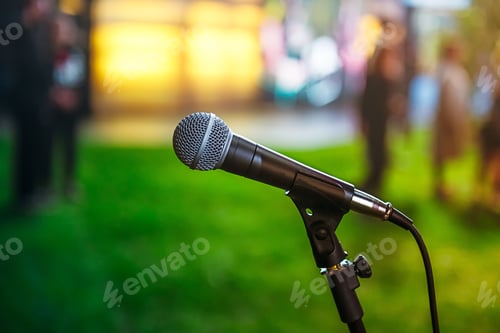 Preview: classic microphone on Abstract blurred bright green background of conference hall or event. Public s