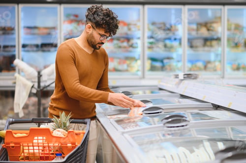Preview: Arab customer choosing frozen food in supermarket refrigerator