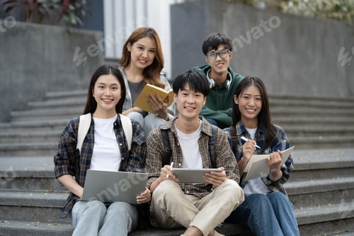 Preview: Potrait of young Asian college students working on group project while sitting on staircase of colle