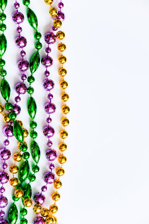 Preview: Mardi Gras background. Gold, green and purple beads on white background. Fat Tuesday symbol.