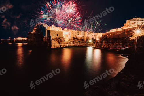 Preview: Night view of the village of Polignano a Mare illuminated by the lights with fireworks