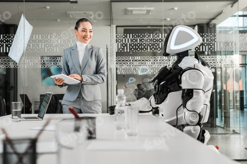 Preview: selective focus of smiling asian businesswoman holding digital tablet while looking at robot