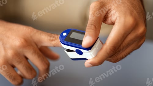 Preview: Male hands using pulse oximeter, closeup photo