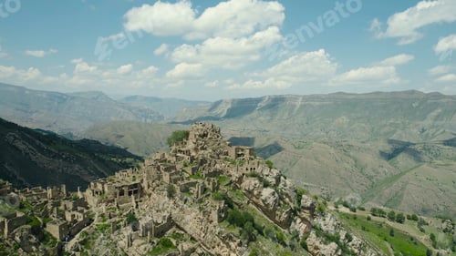 Preview: Ancient stone city on rock on background of mountains. Action. Amazing settlement of rock houses on