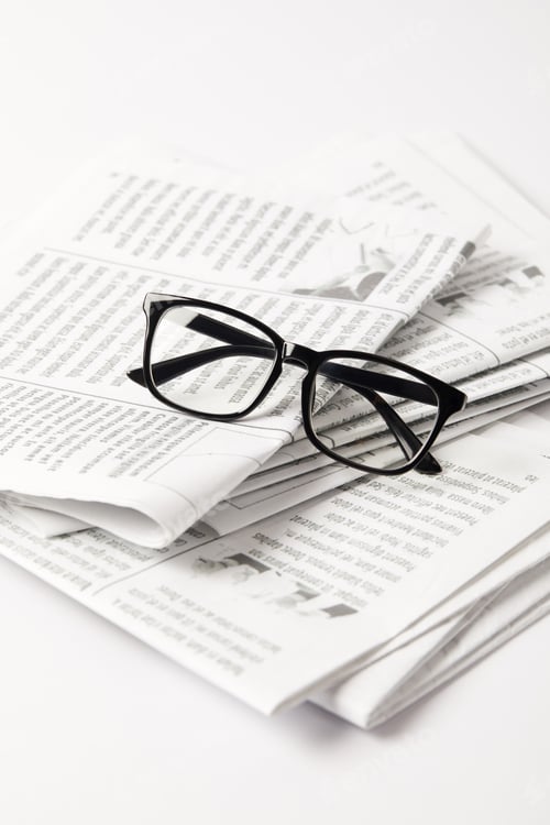 Preview: close up of pile of newspapers and eyesight, on white