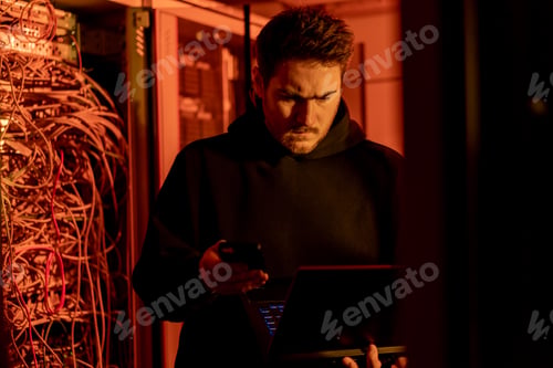 Preview: focused hacker in data center hacking software system vulnerable cyber security server room