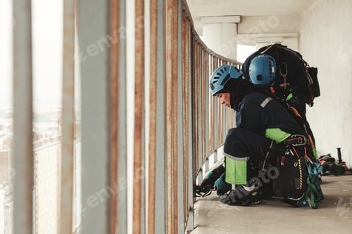 Preview: Industry mountaineer workers in uniform and helmets working on balcony