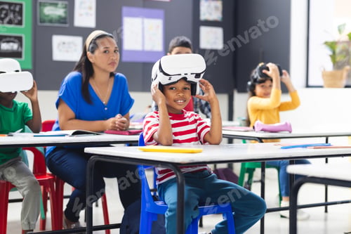 Preview: Biracial female teacher and children using VR sets in classroom