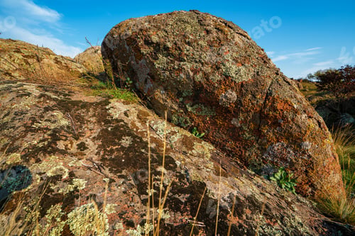 Preview: A small pile of stones in a green-yellow field against the background of a sky in Ukraine