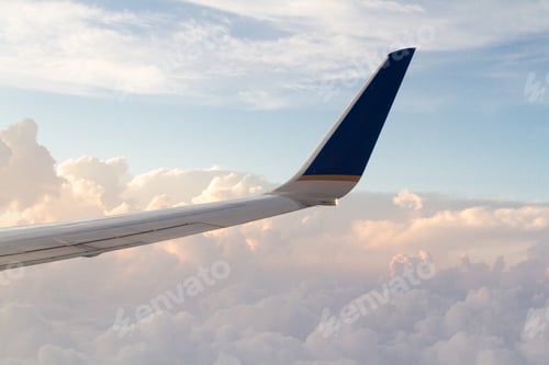Airplane Wing Against Clouds in a Blue Sky
