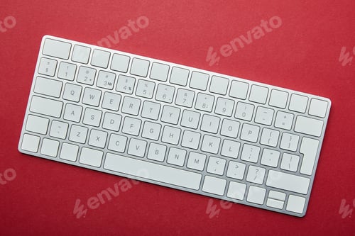 Preview: Top view of white computer keyboard on red background