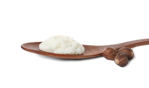 Preview: Shea butter in wooden spoon and nuts isolated on white