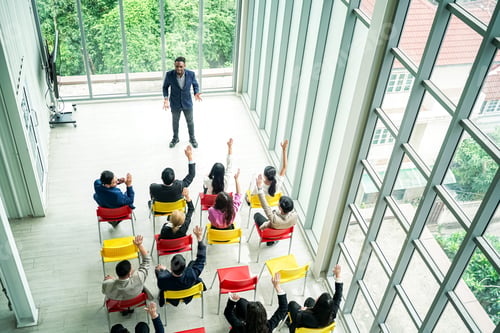 Preview: Raised up hands of large group in seminar class room to agree with speaker at conference seminar