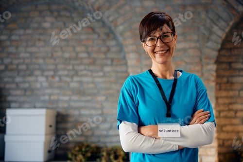 Preview: Happy volunteer with her arms crossed at community center looking at camera.