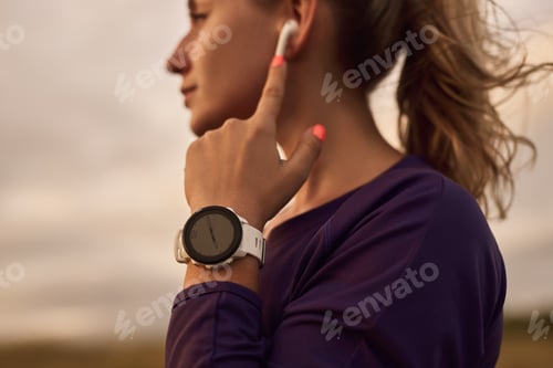 Vista previa: Sportswoman wearing smartwatch during training in nature