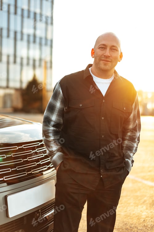 Preview: Casual man standing near his luxury car at the parking