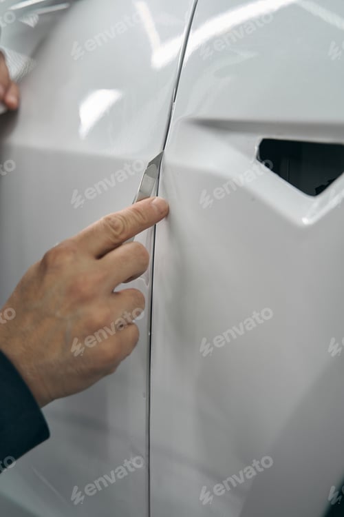 Preview: Hand removing excess PPF on car body panel