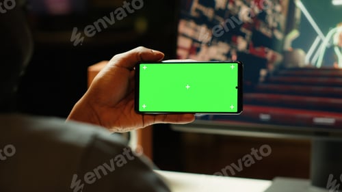 Preview: Man watching content creator on isolated screen smartphone while gaming