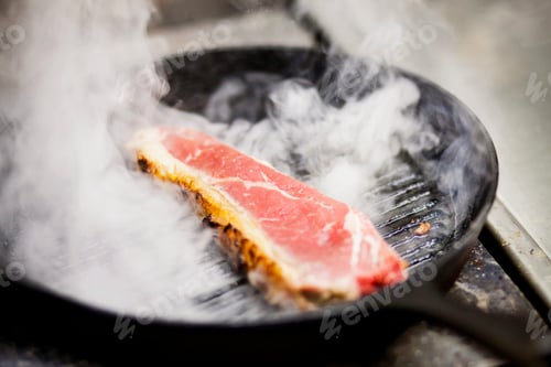 Preview: High angle view of steak being cooked at commercial kitchen