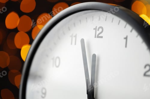 Preview: New Year eve concept with alarm clock against blurred garland