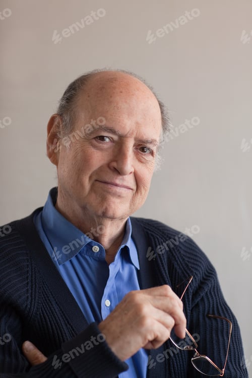 Preview: Portrait of a senior man holding glasses in hand