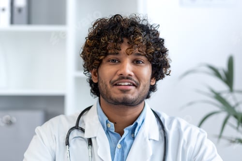 Preview: Close-up portrait of successful smiling hispanic doctor, man smiling and looking at camera, doc