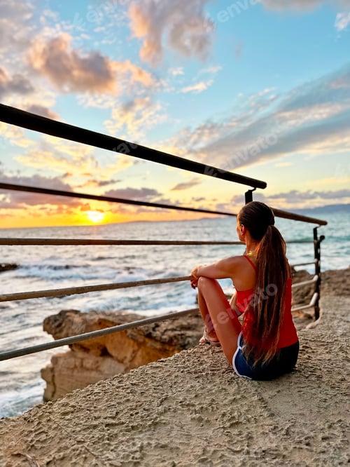 Preview: Young Woman With Long Hair Enjoing Tropical Rocky Beach Landscape In Front Of Sunset