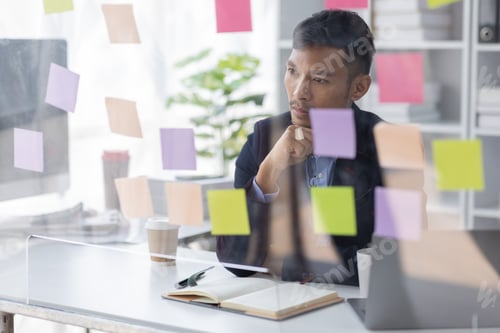 Preview: Concentrated adult business asian man, organizing his busy work week in the office. documents money