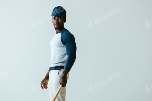 Preview: handsome african american baseball player looking at camera isolated on grey