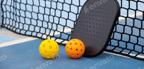 Preview: Pickleball equipment sitting on tennis court by net