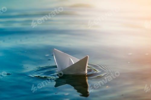 Preview: Close-up of simple small white origami paper boat floating quietly in blue clear river