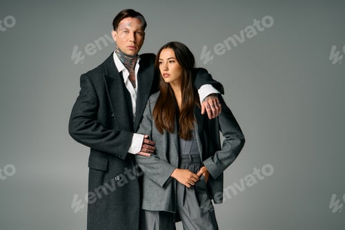 Preview: Young artists showcase modern fashion in stylish gray outfits against a neutral backdrop
