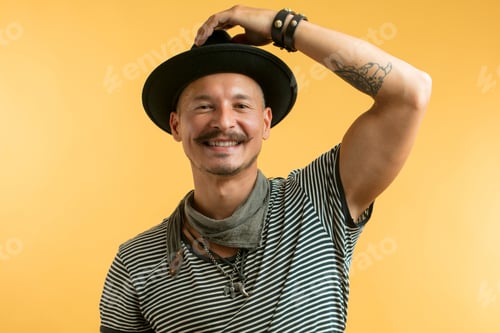 Preview: Happy man with moustache wearing hat isolated over yellow background.
