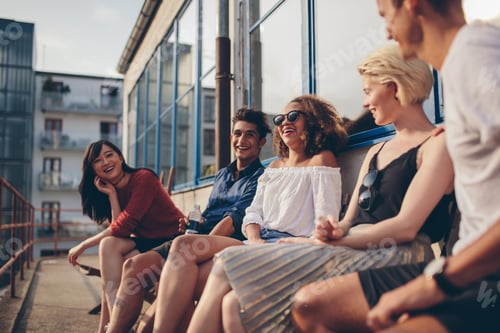 Preview: Multiracial group of friends sitting in balcony and smiling