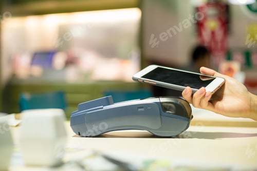 Preview: Customer paying with smartphone inside restaurant