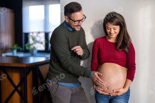 Preview: Beautiful pregnant woman and her handsome husband are smiling while spending time together