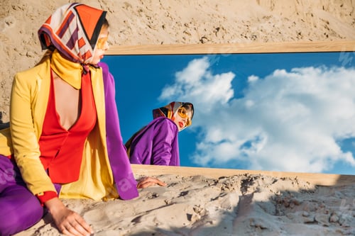 Preview: fashionable model looking at her reflection in mirror