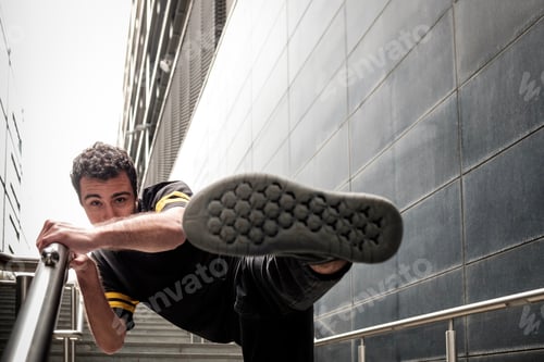 Preview: Young man dancer performing close to modern building.