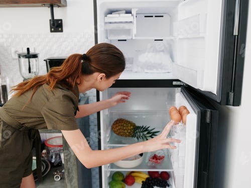 Preview: A woman opened the refrigerator and looks sadly into it, wondering what to cook, defrosted the