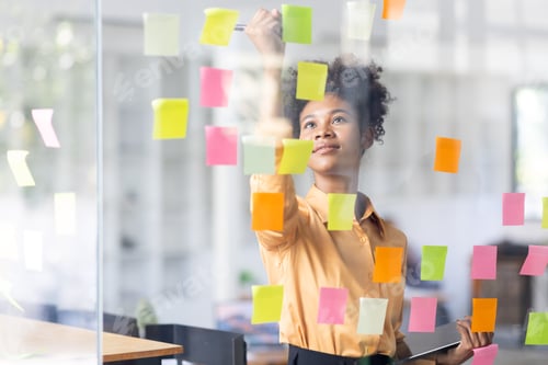 Preview: Business female employee with many conflicting priorities arranging sticky notes commenting and