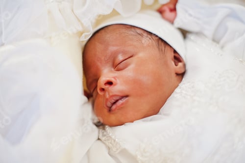 Preview: Small tiny newborn african american baby laying on the bed.