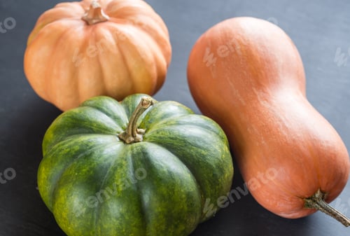 Preview: Three pumpkins on the dark wooden background