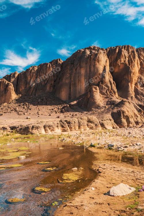 Preview: Narrow river near stone hill in desert
