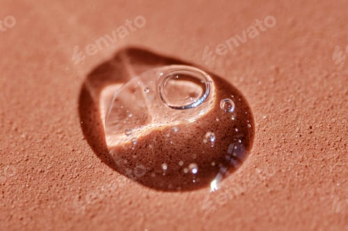 Preview: A drop of cosmetic product on a terracotta background.