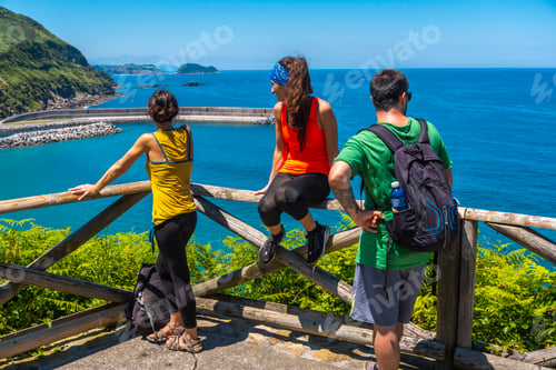 Preview: Three friends looking from the viewpoint at the Orio coast, gipuzkoa, basque country
