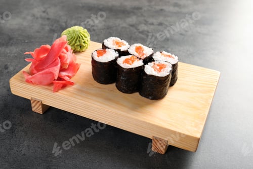 Preview: Serving board with tasty sushi rolls on grey table. Food delivery