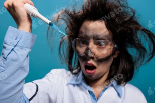 Preview: Crazy mad chemistry reasearcher with dirty face and messy hair experimenting with unknown compounds.