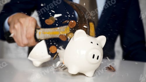 Preview: usinessman using a hammer to smash plenty of coins inside piggybank into pieces