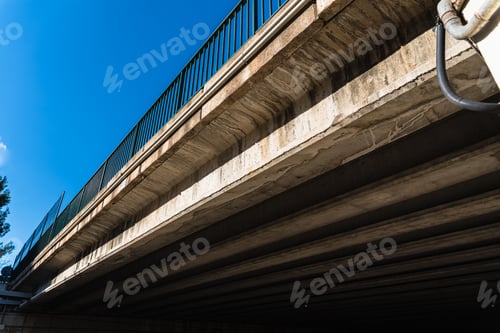 Preview: Cement beams support the weight of a bridge over a road.